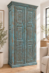 An ornate carved wooden cabinet with a distressed teal-green paint finish,  