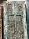 Decorative wooden door with intricate carvings and weathered finish.