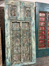 Decorative wooden doors with intricate carvings and weathered finish.