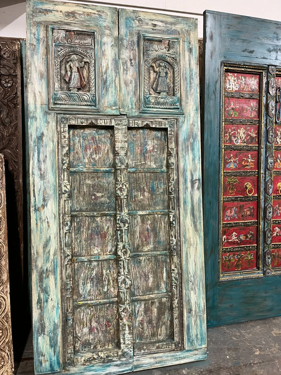 Decorative wooden doors with intricate carvings and weathered finish.