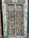 Vintage wooden door with intricate carvings and weathered finish